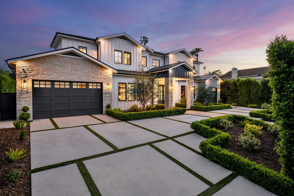 Modern front garden with stone path, clipped planting and low lights at dusk