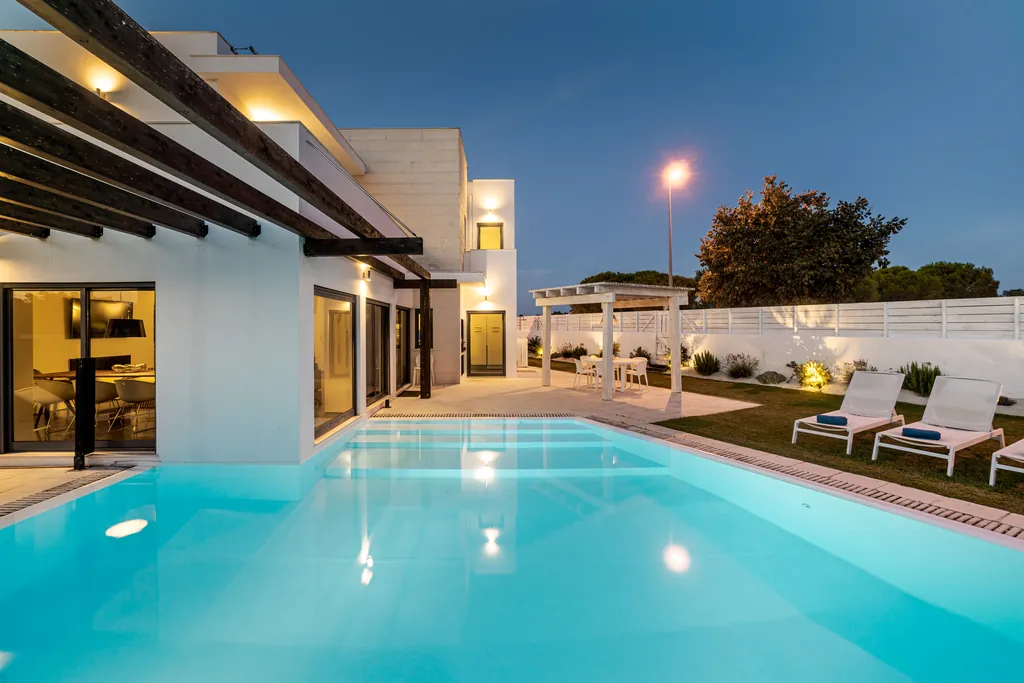 Illuminated pool and pergola at night