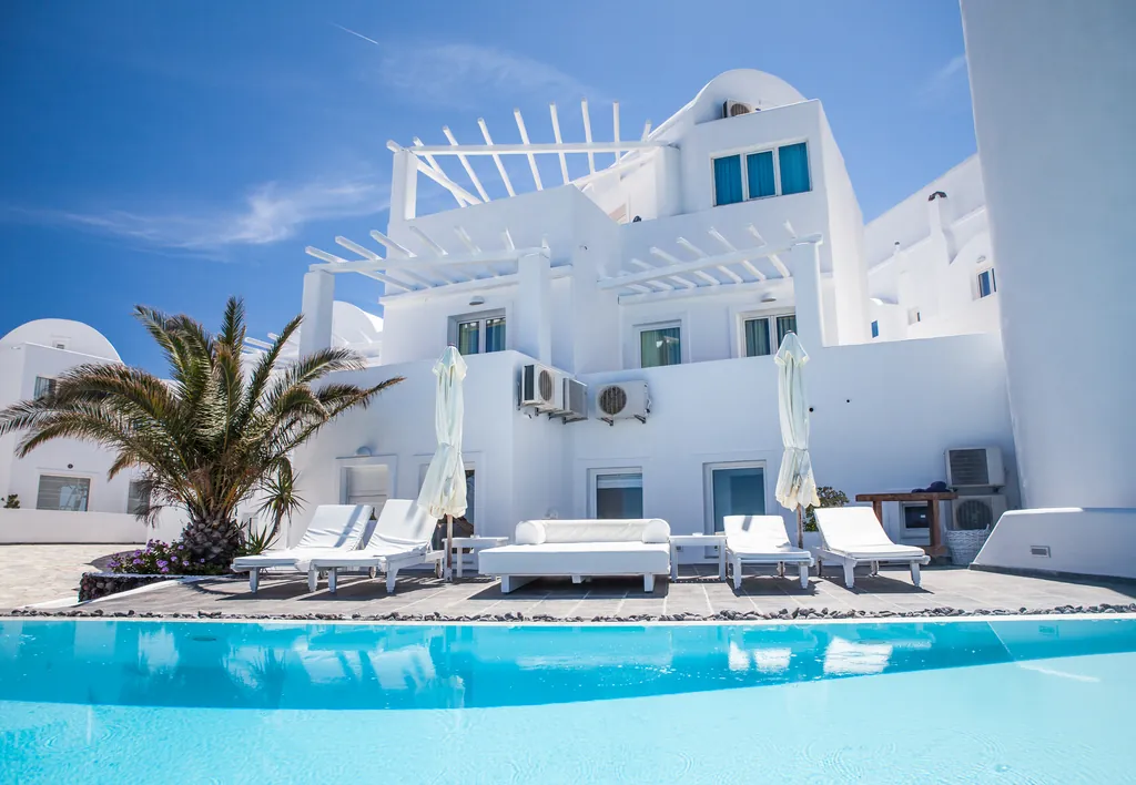 White villa with pergola, sun loungers and a turquoise pool