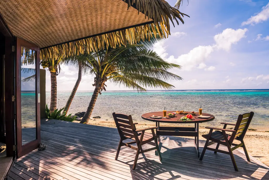 Wooden deck terrace with table and chairs facing the beach